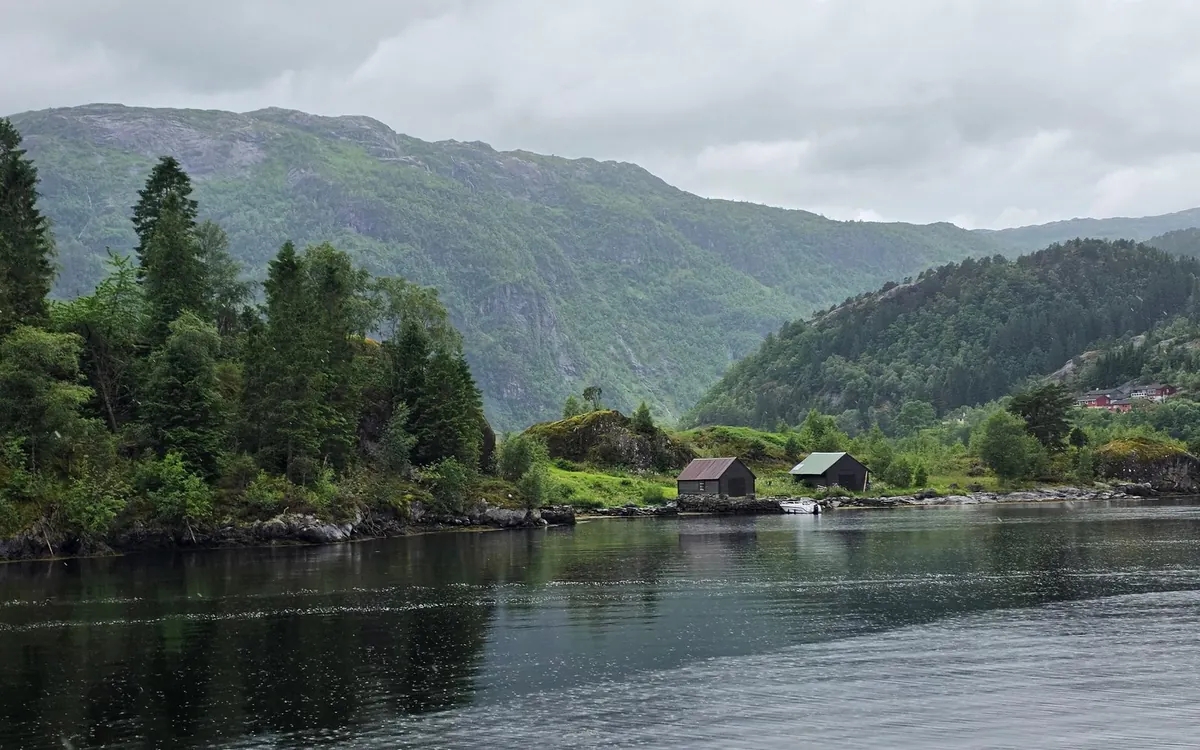 A cruise boat sailing the narrow UNESCO-listed Nærøyfjord between steep walls
